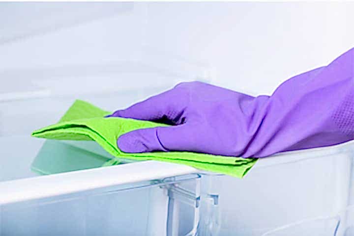 Рука в перчатке протирает тряпкой стол